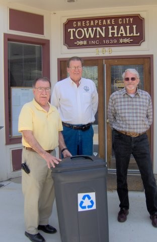 Men showing new recycling bins in front of Town Hall